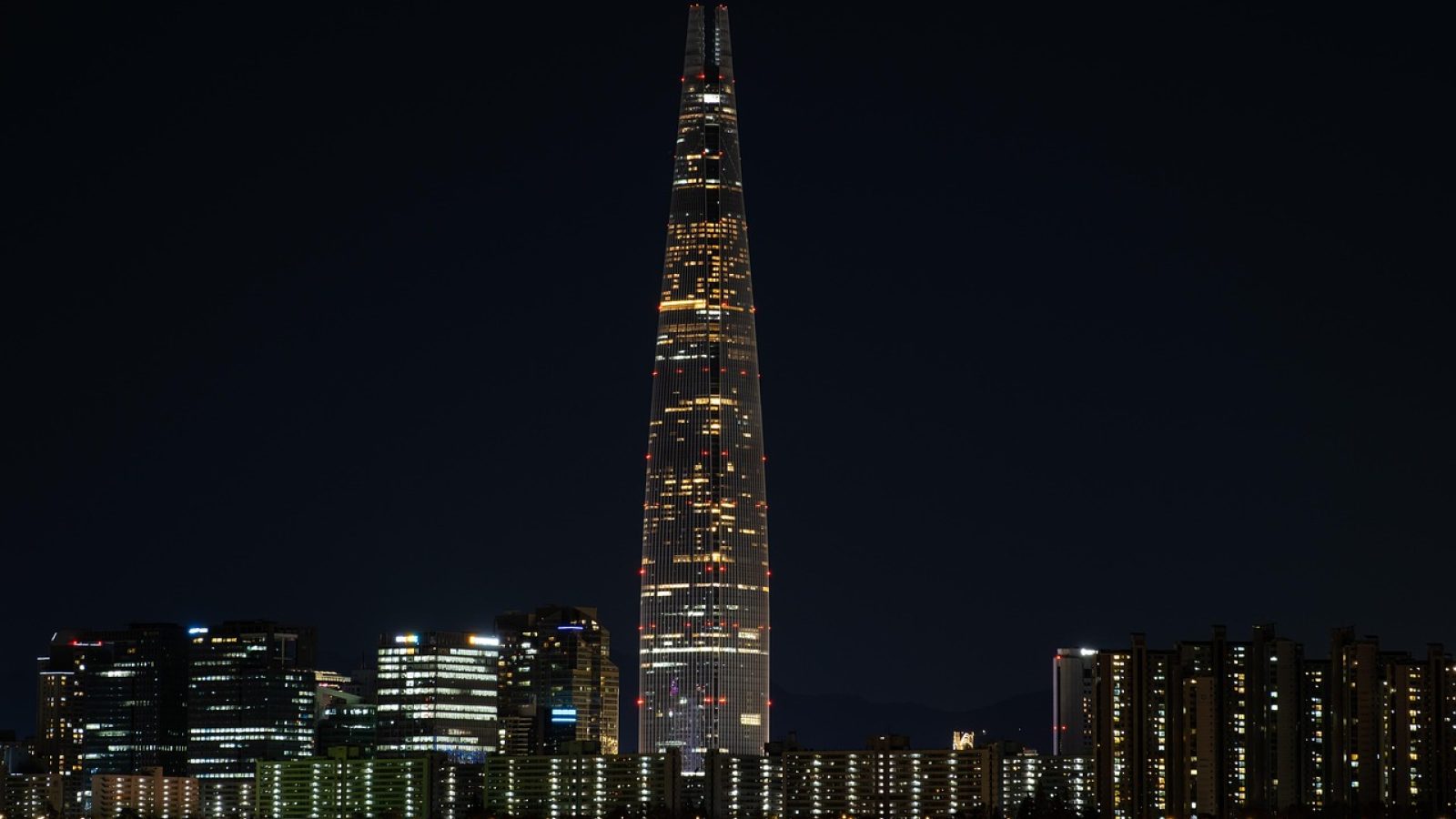 沈阳洗浴论坛品牌形象大图，展现沈阳城市夜景与温暖灯光交织的洗浴休闲文化氛围，钴蓝与橙红色调映衬出平台的专业与热情